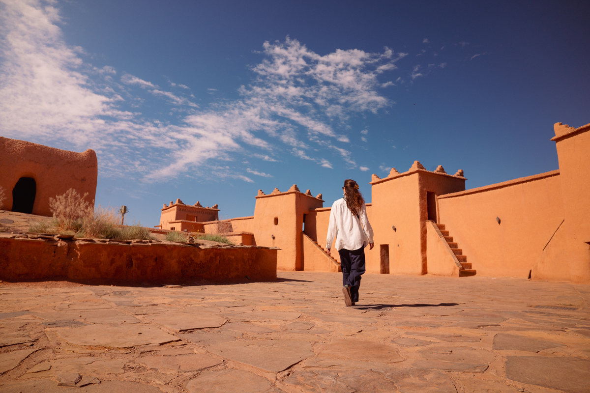 A woman crossing a kasbah square