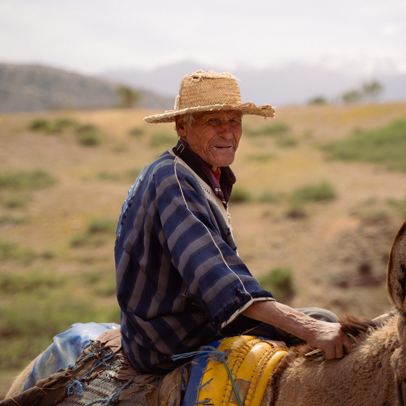 A man on a donkey in a straw hat